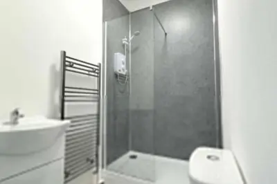 a bathroom with a shower and a toilet and a sink at 3-BR Home in Wigan | Free Wi-Fi | Comfortable Stay in Ince-in-Makerfield