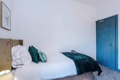 a bedroom with a bed with a blue door at 3-BR Home in Wigan | Free Wi-Fi | Comfortable Stay in Ince-in-Makerfield