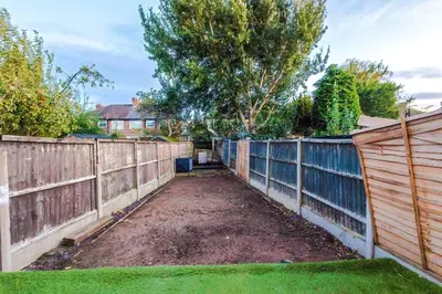 a garden with a wooden fence and a yard at Comfy 3-BR Wirral Home | Free Parking & Wi-Fi in Bidston