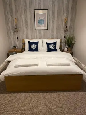 a bedroom with a large bed with blue pillows at Cosy Georgian Quarter Apartment - Sleeps 4 in Liverpool