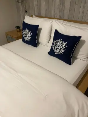 a white bed with two blue pillows on it at Cosy Georgian Quarter Apartment - Sleeps 4 in Liverpool