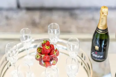 a table with a bottle of champagne and a bowl of strawberries at Cosy Georgian Quarter Apartment - Sleeps 4 in Liverpool