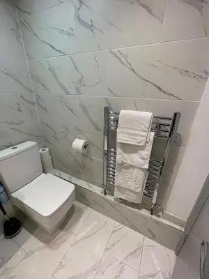 a white bathroom with a toilet and towels at Cosy Georgian Quarter Apartment - Sleeps 4 in Liverpool