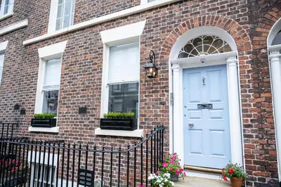 a brick house with a blue door and windows at Cosy Georgian Quarter Apartment - Sleeps 4 in Liverpool