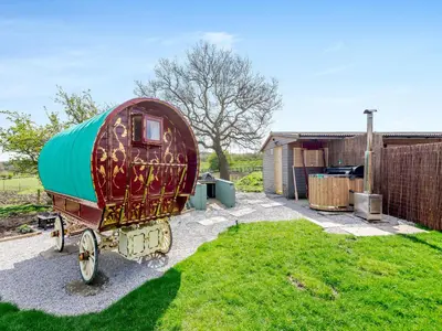 a train car sitting in the grass in a yard at Harans Vardo - Uk42959 in Altham