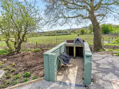a green building with a bench in a field at Harans Vardo - Uk42959 in Altham