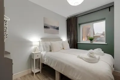 a bedroom with a large white bed with a window at Beach Stays - Ground Floor 2 Bed Apartment - Free Parking in Cleveleys