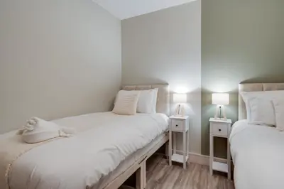two beds in a small room with two lamps at Beach Stays - Ground Floor 2 Bed Apartment - Free Parking in Cleveleys