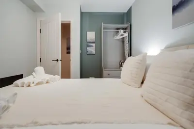 a white bed with a stuffed animal on top of it at Beach Stays - Ground Floor 2 Bed Apartment - Free Parking in Cleveleys