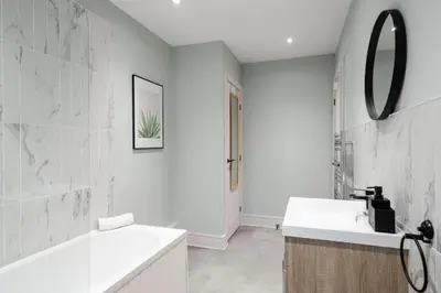 a white bathroom with a sink and a mirror at Beach Stays - Ground Floor 2 Bed Apartment - Free Parking in Cleveleys