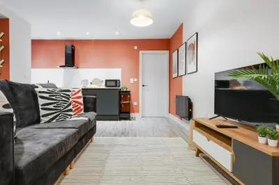 a living room with a couch and a flat screen tv at Beach Stays - Ground Floor 2 Bed Apartment - Free Parking in Cleveleys