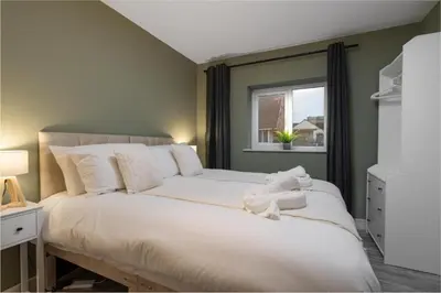 a bedroom with a large white bed with a window at Beach Stays - Ground Floor 2 Bed Apartment - Free Parking in Cleveleys