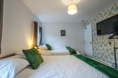 a bedroom with two beds and a flat screen tv at Blackpool Retreat Group Stays in Blackpool