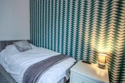 a bedroom with a bed and a table with a lamp at Blackpool Retreat Group Stays in Blackpool