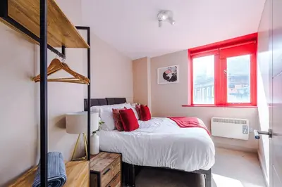 a bedroom with a bed and a red window at Cozy 2BR Flat in the Heart of Wigan Wallgate in Wigan