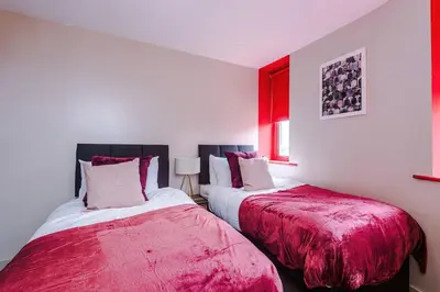 two beds sitting next to each other in a bedroom at Cozy 2BR Flat in the Heart of Wigan Wallgate in Wigan
