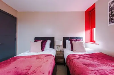 two beds sitting next to each other in a room at Cozy 2BR Flat in the Heart of Wigan Wallgate in Wigan