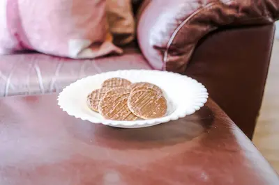 two cookies on a paper plate on a couch at Cozy 2BR Flat in the Heart of Wigan Wallgate in Wigan