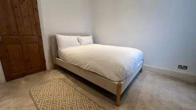 a small bed in a corner of a room at Liverpool Maple House 3Bed - Walk to Anfield stadium in Liverpool