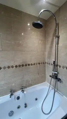 a bath tub with a shower in a bathroom at Liverpool Maple House 3Bed - Walk to Anfield stadium in Liverpool