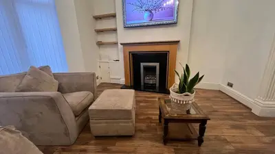 a living room with a couch and a fireplace at Liverpool Maple House 3Bed - Walk to Anfield stadium in Liverpool
