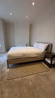 a bedroom with a large bed and a table at Liverpool Maple House 3Bed - Walk to Anfield stadium in Liverpool