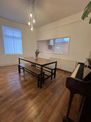 a living room with a table and a piano at Liverpool Maple House 3Bed - Walk to Anfield stadium in Liverpool