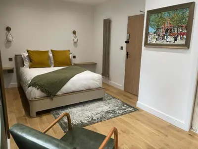 a bedroom with a bed and a chair and a door at Auberge in Lytham St Annes