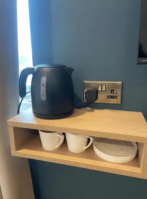 a slow cooker sitting on a wooden shelf with cups at Auberge in Lytham St Annes