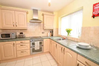 a kitchen with white cabinets and a sink and a window at Convenient 2 Bedroom Apartment in Preston w WiFi in Preston