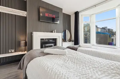 a bedroom with two beds and a fireplace at The Crews Quarters Anfield - Sleeps 9 - Modern in Liverpool