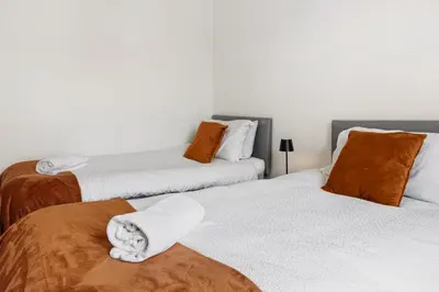 two beds with towels on them in a bedroom at The Crews Quarters Anfield - Sleeps 9 - Modern in Liverpool