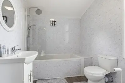 a bathroom with a tub and a toilet and a sink at The Crews Quarters Anfield - Sleeps 9 - Modern in Liverpool
