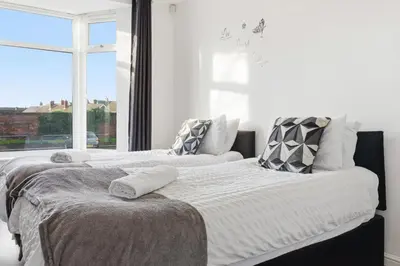 two beds in a room with a window at The Crews Quarters Anfield - Sleeps 9 - Modern in Liverpool