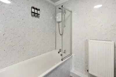 a shower with a glass door in a bathroom at The Crews Quarters Anfield - Sleeps 9 - Modern in Liverpool