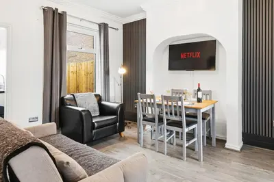 a living room with a table and chairs and a couch at The Crews Quarters Anfield - Sleeps 9 - Modern in Liverpool