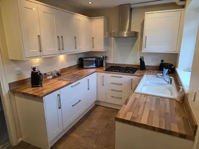 a kitchen with white cabinets and a sink at Peplow Place, A Great Two Bedroom Retreat in Heysham
