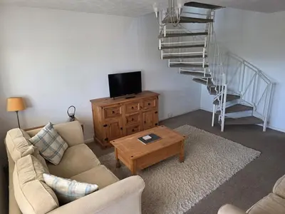 a living room with a couch and a staircase at Peplow Place, A Great Two Bedroom Retreat in Heysham