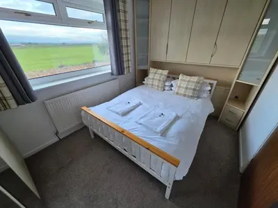 a bed in a room with a large window at Peplow Place, A Great Two Bedroom Retreat in Heysham