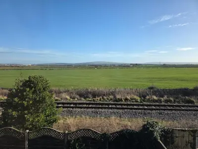 a view of a green field and train tracks at Peplow Place, A Great Two Bedroom Retreat in Heysham