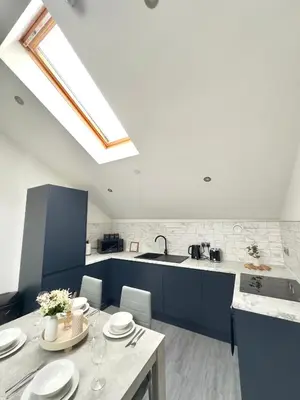a kitchen with blue cabinets and a sink and a table at Cumberland Street Apartments by Happy Days in Liverpool
