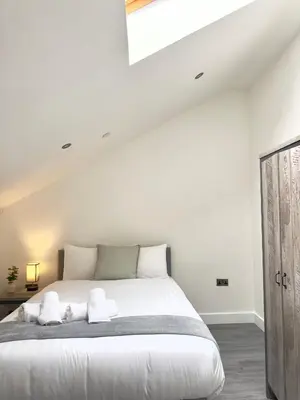 a white bedroom with a large bed with white pillows at Cumberland Street Apartments by Happy Days in Liverpool