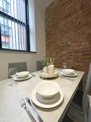 a table with plates and silverware on top of it at Cumberland Street Apartments by Happy Days in Liverpool