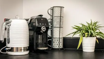 a kitchen counter with a coffee maker and two plants at Modern 2BR Near Liverpool ONE & Parking in Liverpool