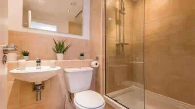 a bathroom with a shower and a toilet and a sink at Modern 2BR Near Liverpool ONE & Parking in Liverpool