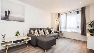 a living room with a couch and a table at Modern 2BR Near Liverpool ONE & Parking in Liverpool