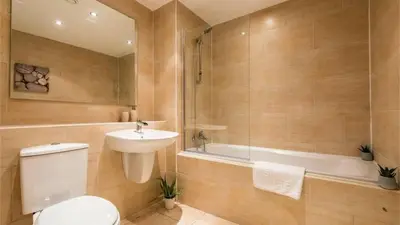 a bathroom with a toilet and a sink and a tub at Modern 2BR Near Liverpool ONE & Parking in Liverpool