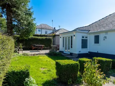 a small white house with a yard with bushes at Luxury 3-Bedroom, 3-Bath Home in Dalton-in-Furness in Dalton in Furness