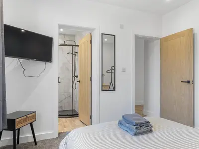 a bedroom with a bed with a television and a shower at Luxury 3-Bedroom, 3-Bath Home in Dalton-in-Furness in Dalton in Furness