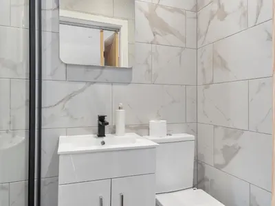 a white bathroom with a sink and a mirror at Luxury 3-Bedroom, 3-Bath Home in Dalton-in-Furness in Dalton in Furness